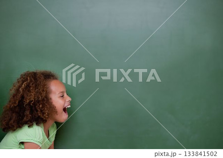 Girl is leaning forward with curly hair against green chalkboard in flat design, showing open mouth 133841502