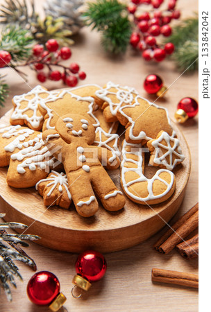 Gingerbread cookies on wooden plate with christmas decor 133842042