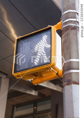 Yellow pedestrian crossing signal is glowing on metal pole under overhang, flat design, copy space Yellow pedestrian crossing signal is glowing on metal pole under overhang, flat design, copy space 133843049