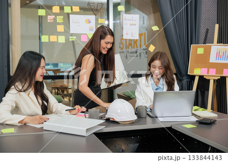 Business women meet, busy team people work on project during engaging meeting, collaborating in conference room, sharing ideas, planning company growth, smiling professionally. Business women meet, busy team people work on project during engaging meeting, collaborating in conference room, sharing ideas, planning company growth, smiling professionally. 133844143