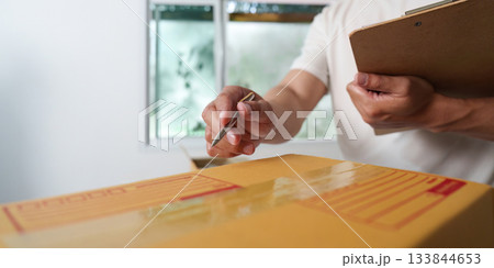 Delivery Management. A courier preparing to deliver packages with a clipboard. Delivery Management. A courier preparing to deliver packages with a clipboard. 133844653