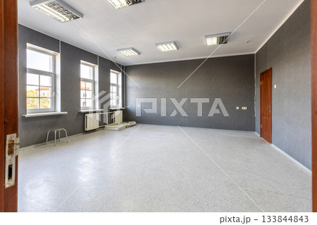 Empty Office Room with Grey Walls and Bright Windows 133844843