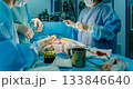 The surgeon sutures a patient's skin during surgery. 133846640