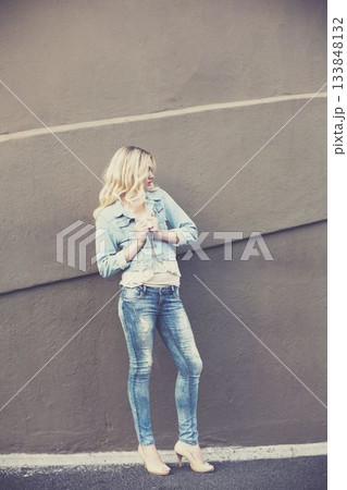 Young woman while standing against wall Young woman while standing against wall 133848132