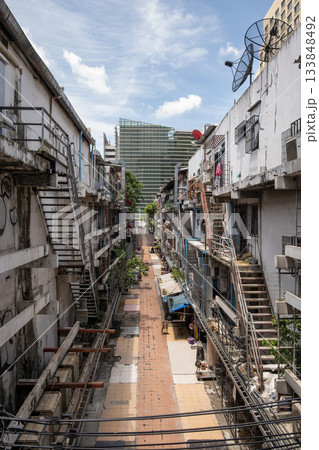 Narrow alleyway in Bangkok showcasing urban architecture and vibrant street life atmosphere Narrow alleyway in Bangkok showcasing urban architecture and vibrant street life atmosphere 133848492