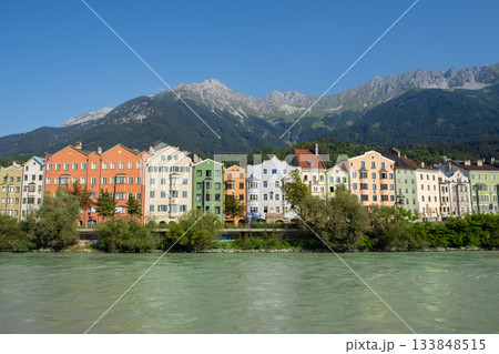 Colorful riverside houses with alpine mountain backdrop in Innsbruck Austria 133848515