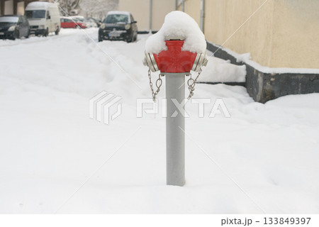 Snow-Covered Fire Hydrant Standing in Winter Street 133849397