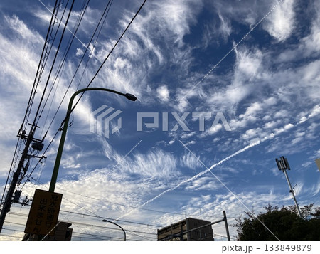 にぎやかな秋の雲を横切る飛行機雲 133849879