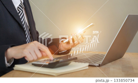 businessman using smart phone and calculator in front of laptop, infographic showing increase arrow graph on bar chart for growth business of year 2026. new opportunity, challenge, strategy, visions businessman using smart phone and calculator in front of laptop, infographic showing increase arrow graph on bar chart for growth business of year 2026. new opportunity, challenge, strategy, visions 133850734