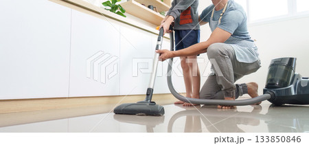 Home Cleaning. Father and son vacuuming floor together. 133850846