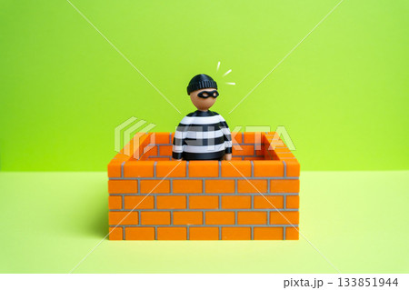 Criminal is surrounded by walls on all sides. Rights and freedoms are restricted. The prisoner sits in jail. Justice system challenges, detention issues and public safety for legal or social research. 133851944