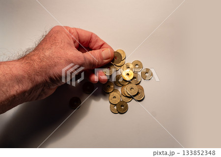 Hand picking up japanese 5 yen coins Hand picking up japanese 5 yen coins 133852348