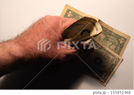 Hand holding old one dollar bills cash economy 133852368