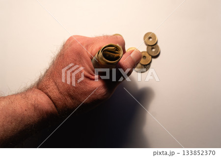 Hand gripping rolled japanese yen with coins Hand gripping rolled japanese yen with coins 133852370