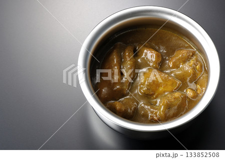 シルバーの食器に入ったチキンカレーを黒背景で撮影 133852508