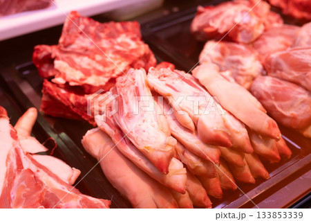 Raw pig feet on counter of butcher shop. 133853339