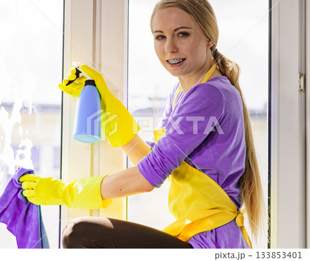 Girl cleaning window at home 133853401