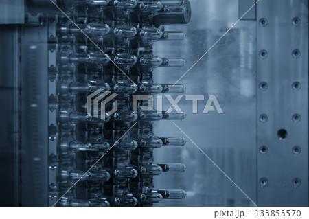 Close up scene of injection process group of preform shape of PET bottle products in the blue scene Close up scene of injection process group of preform shape of PET bottle products in the blue scene 133853570