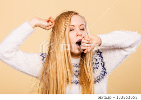 Sleepy yawning teenage woman in jumper 133853655
