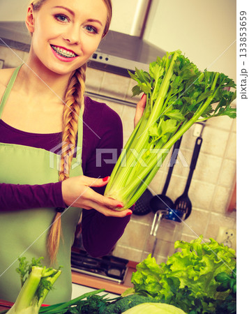 Woman in kitchen with green vegetables Woman in kitchen with green vegetables 133853659