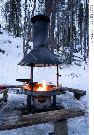 outdoor fire pit burning in snowy winter forest in Finnish lapland outdoor fire pit burning in snowy winter forest in Finnish lapland 133853773