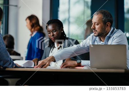 Diverse Business Colleagues Discussing Project in Modern Open Plan Office Diverse Business Colleagues Discussing Project in Modern Open Plan Office 133853783