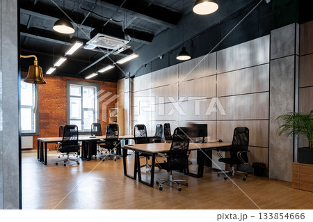 Modern office space with several workstations and natural light on a weekday 133854666