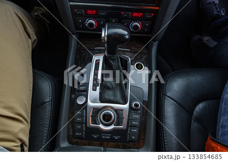 Close-up view of a modern car gearshift and controls on a leather interior 133854685