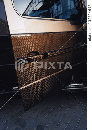 Car door with a unique texture reflecting light in a modern urban setting 133854698