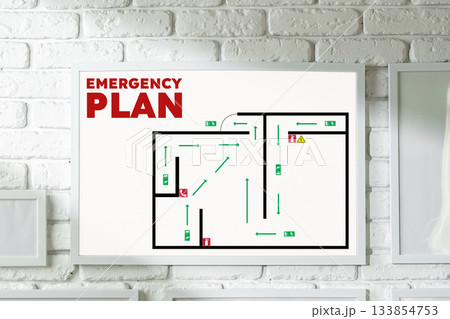 Emergency plan layout displayed on a wall with clear exit routes and safety instructions Emergency plan layout displayed on a wall with clear exit routes and safety instructions 133854753