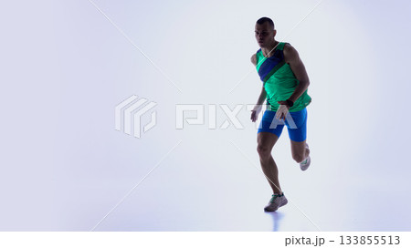 Athlete running forward in studio minimal background Athlete running forward in studio minimal background 133855513