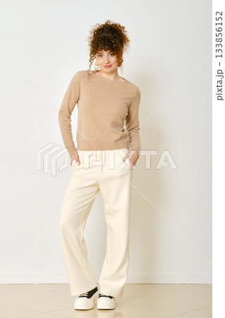 Model poses in stylish outfit for casual fashion shoot in a bright studio setting 133856152