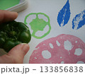 葉っぱやレンコンやピーマンの切れ端等に絵の具をつけ判子にして色々な模様をスタンプする様子 133856838