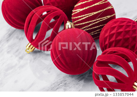 Red Christmas ball decorations, velvet baubles on marble table background, closeup 133857044