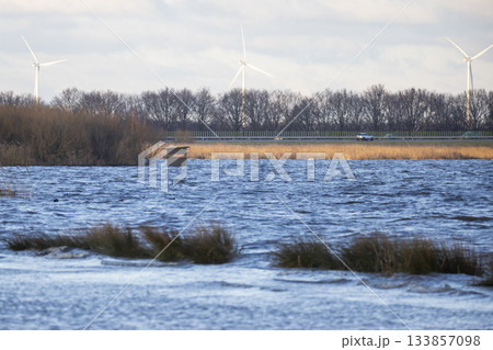 Flooded bird hide at Eemmeer in Eempolder showing high water levels and wind turbines in background 133857098