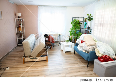 Young man assembling sofa in new apartment Young man assembling sofa in new apartment 133857946