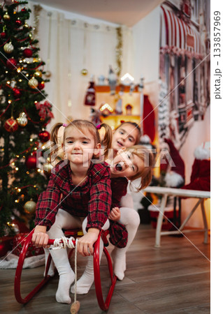 Little girls playing with rocking horse on Christmas eve Little girls playing with rocking horse on Christmas eve 133857969