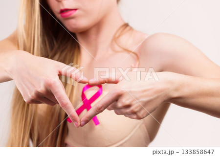 Woman with pink cancer ribbon on breast Woman with pink cancer ribbon on breast 133858647