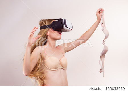 Girl in virtual reality goggles holds bra 133858650