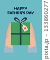 Hands holding a green gift box with blue ribbon and heart tag under Happy Fathers Day text. 133860277