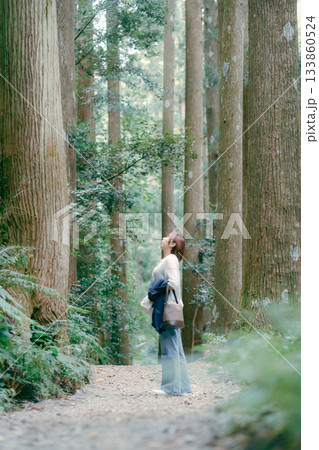 聖地巡礼で杉林を歩く女性 133860524