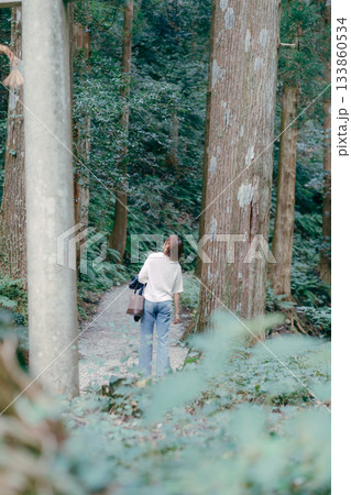 聖地巡礼で杉林を歩く女性 133860534