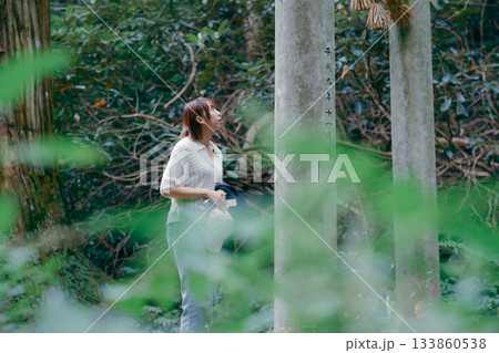 聖地巡礼で杉林を歩く女性 133860538