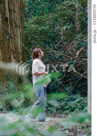 聖地巡礼で杉林を歩く女性 133860539