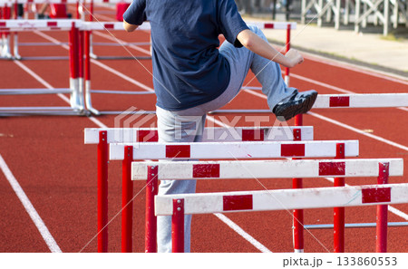 Young Athlete Practicing Hurdles Trail Leg Drill on a Track 133860553