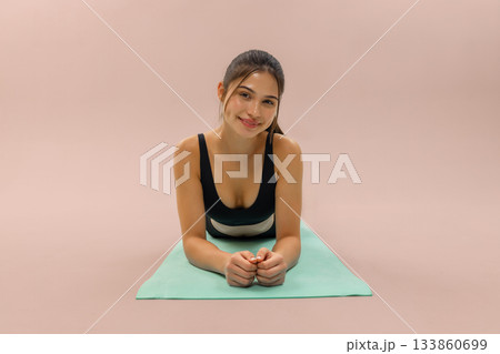 Young woman doing fitness plank on yoga mat in studio, wellness and workout training with yoga mat, healthy lifestyle and fitness routine, sport motivation and home workout concept. 133860699