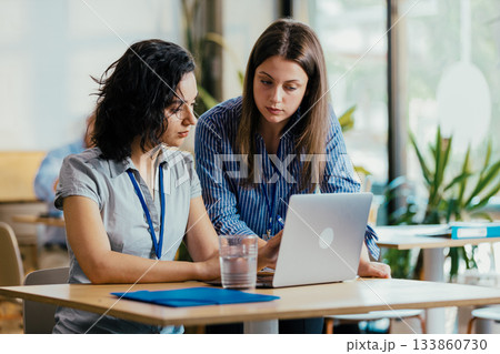 Two Female Startup Team Members Preparing Pitch Presentation Notes at Conference Venue Cafe 133860730