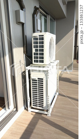 マンションのベランダに二段に設置されたエアコン室外機 133861237