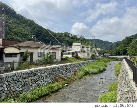 電車の窓から見た高尾山の麓の町並み 133863672