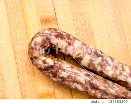 Sausage on a wooden board. 133863809
